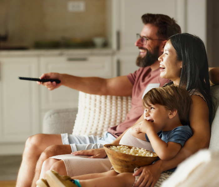 Family watching TV at home. Rent with Minto Apartments.